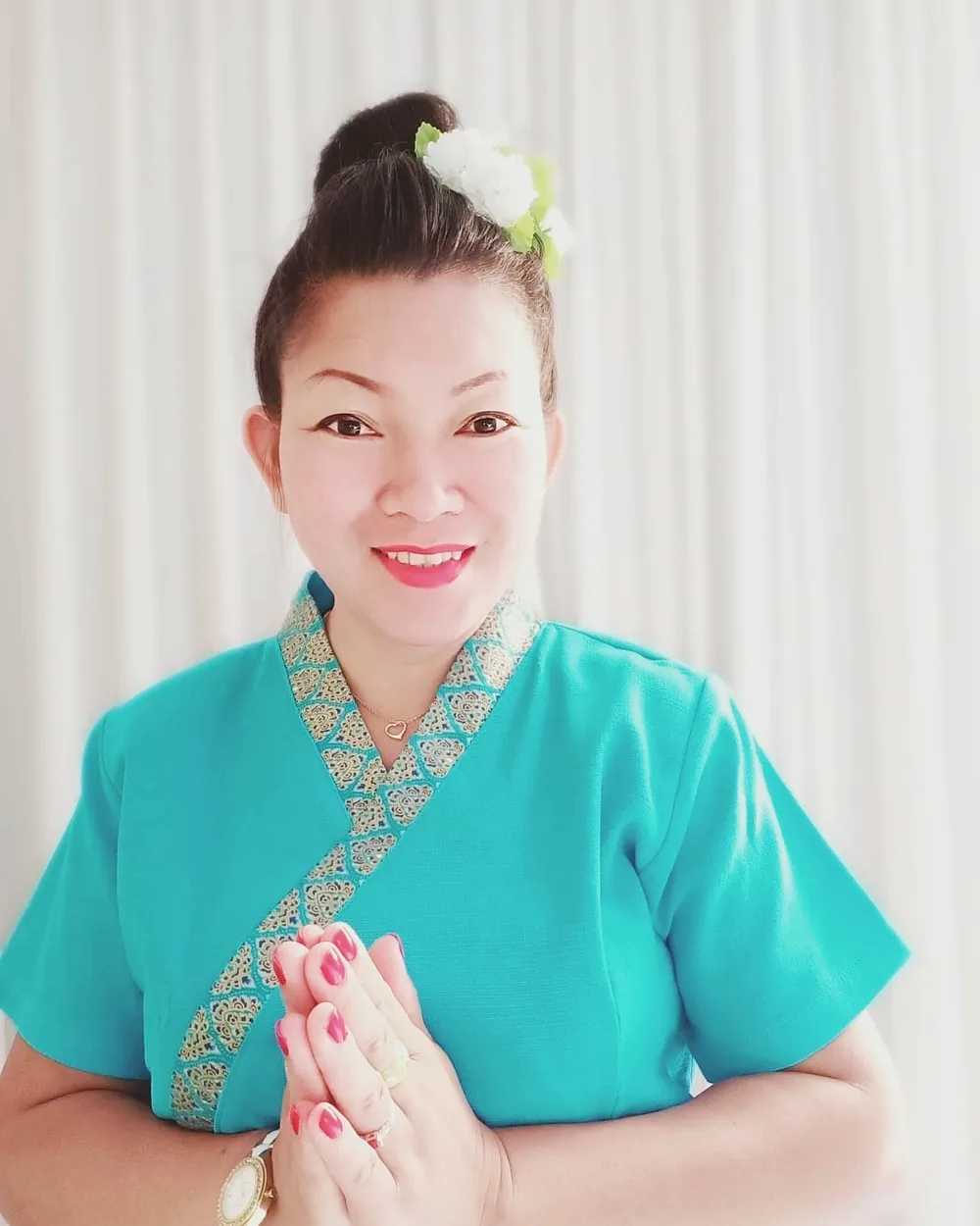 Natthanan Horn, Inhaberin von HomeSabay, im traditionellen thailändischen Gewand mit Wai-Gruß